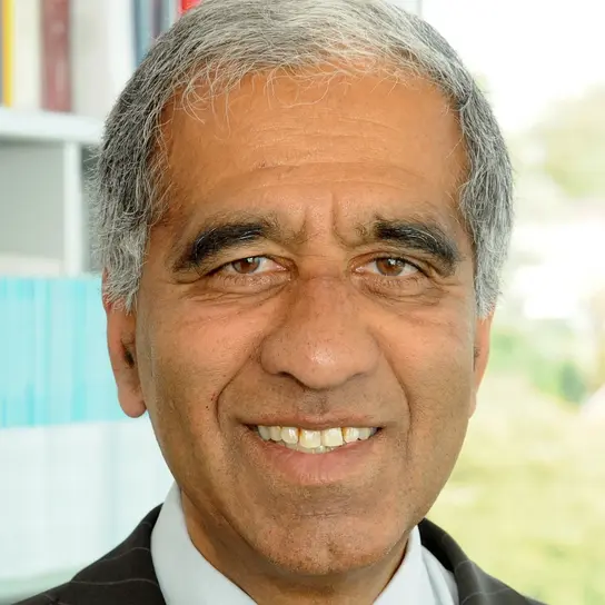 Ein Portrait von Herrn Latif, einem Mann mit dunkler Haut und kurzem, grauen, lockigen Haar. Er lächelt freundlich in die Kamera.