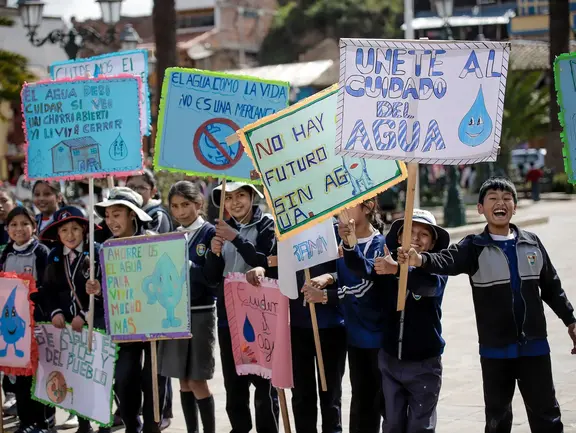 Peruanische Kinder halten Plakate hoch, mit denen sie für sauberes Wasser demonstrieren.