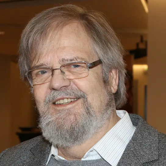 Ein Portrait von Lutz Beisel, einem weißen Mann mit kurzem grauen Haar, Bart und Brille.