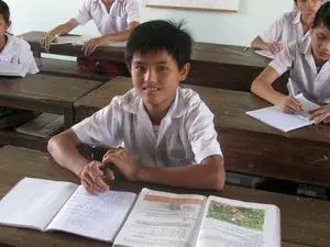 Vietnamesische Kinder in der Schule an ihren Arbeitsheften.