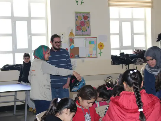 Eine Gruppe von Kindern und Erwachsenen im Klassenraum.